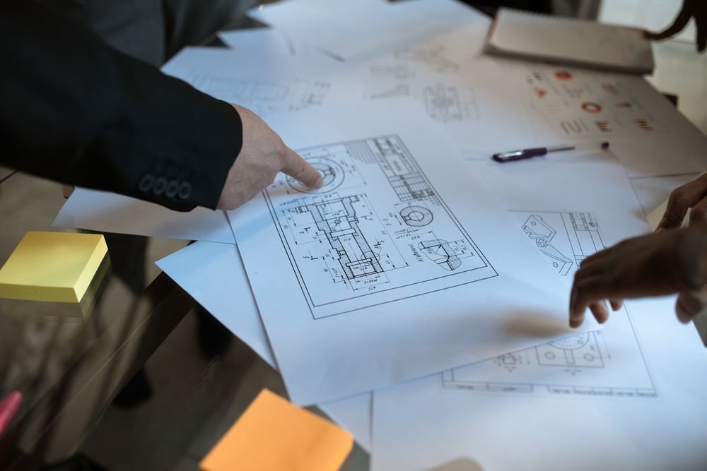A team cross-checking details on printed technical plans